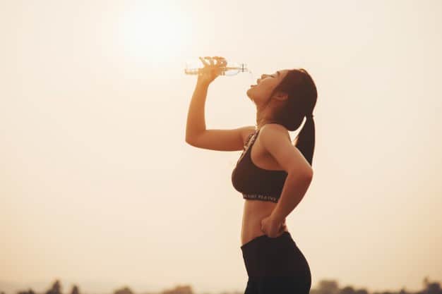 a woman drinking water her run