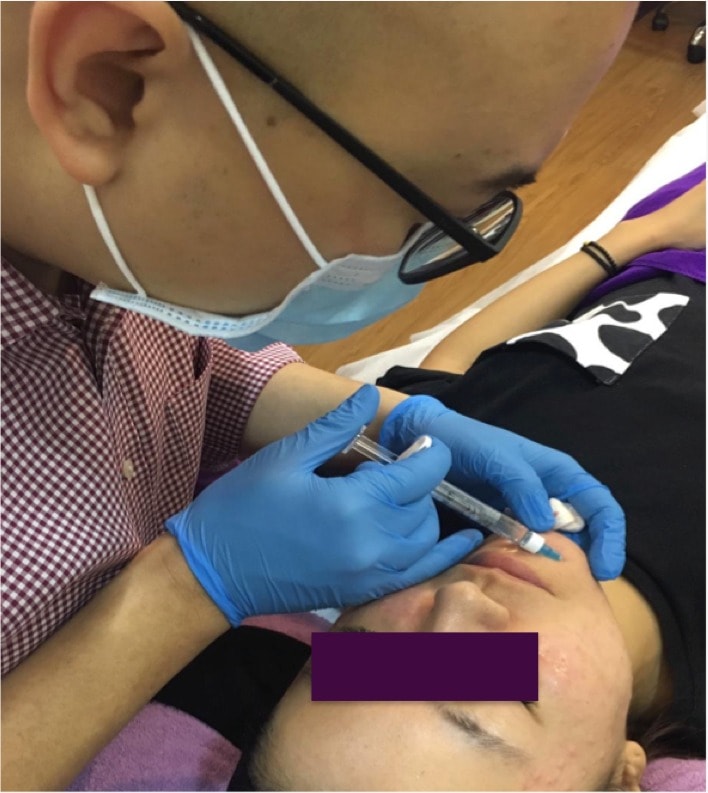 Dr Heng administering an injection to an unknown patient